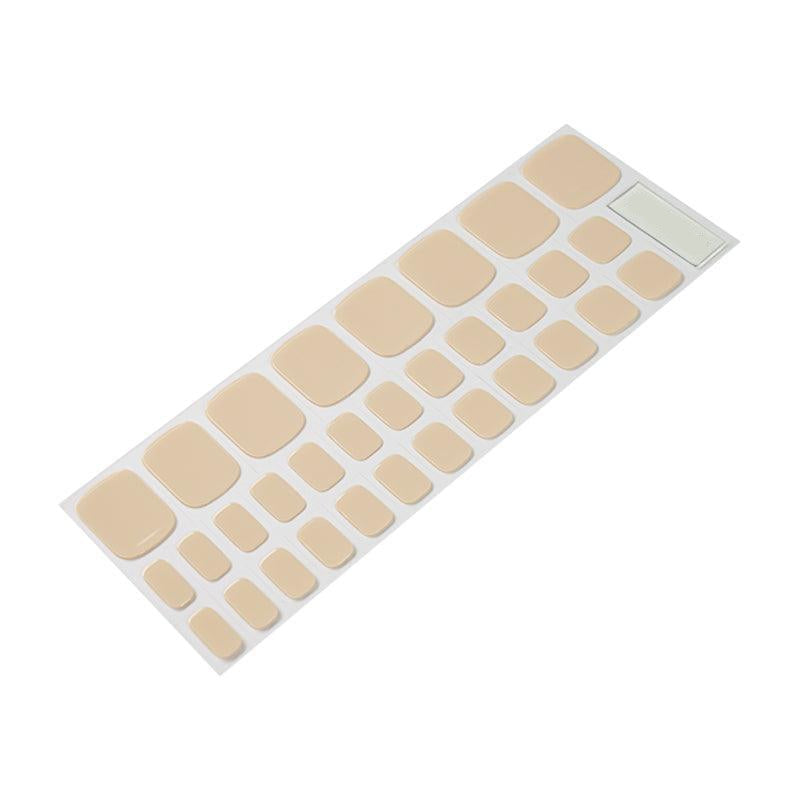 Sheet of creamy, beige gel toenail stickers in various sizes with a soft nude-beige color and glossy texture.