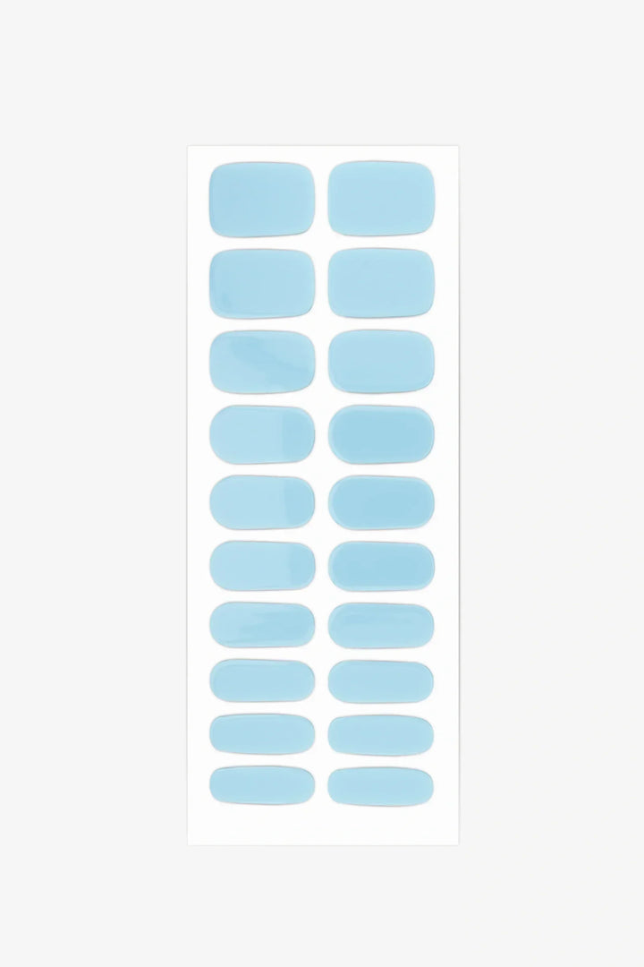 Sheet of semi-cured gel nail wraps in pale sky-blue tones with a clean, high-gloss surface.
