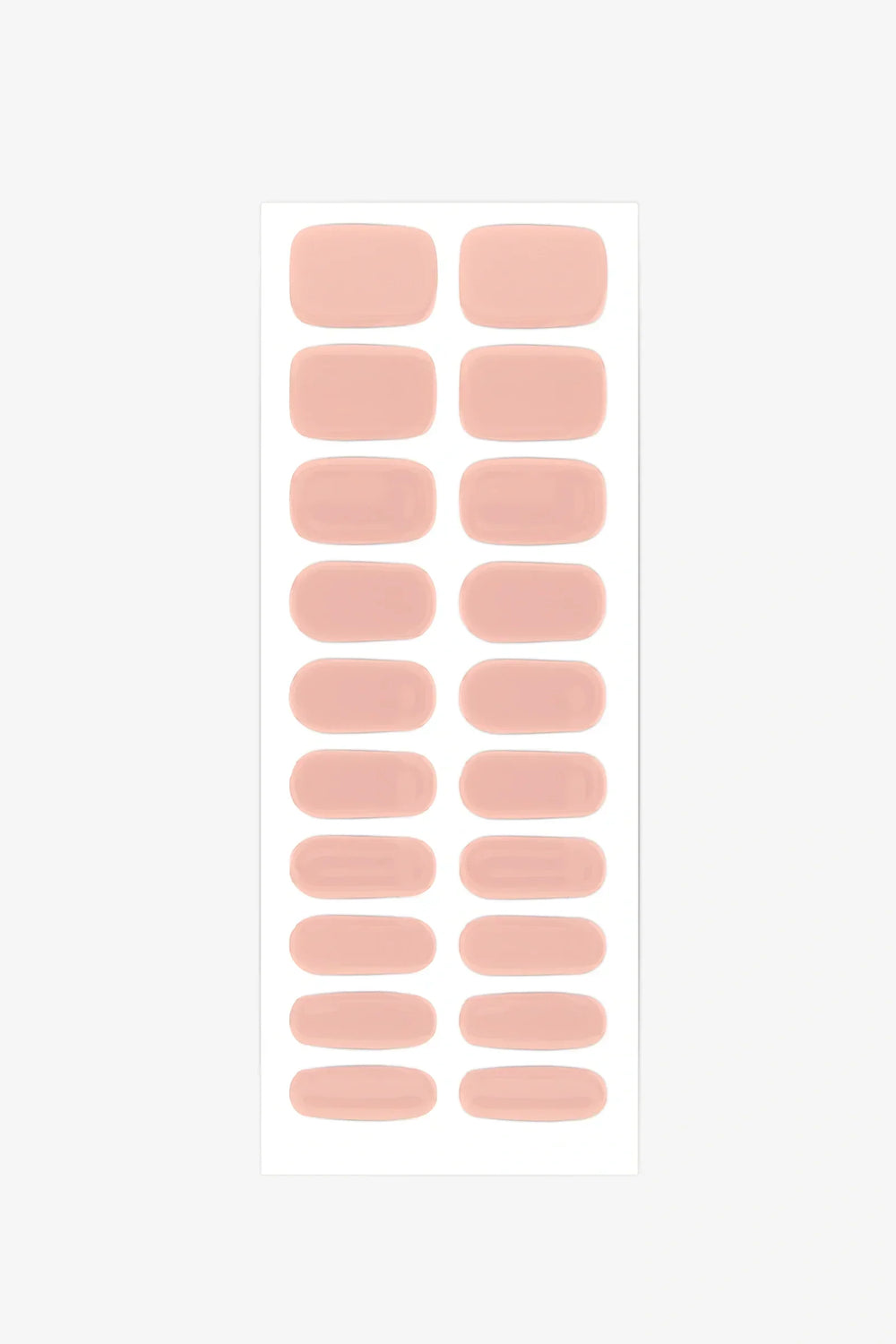 Sheet of soft peach semi-cured gel nail strips with nude coral tones and glossy finish.