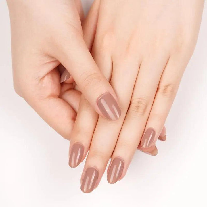 Warm taupe gel nail wraps with smooth high-shine finish on light skin tone under soft neutral lighting.